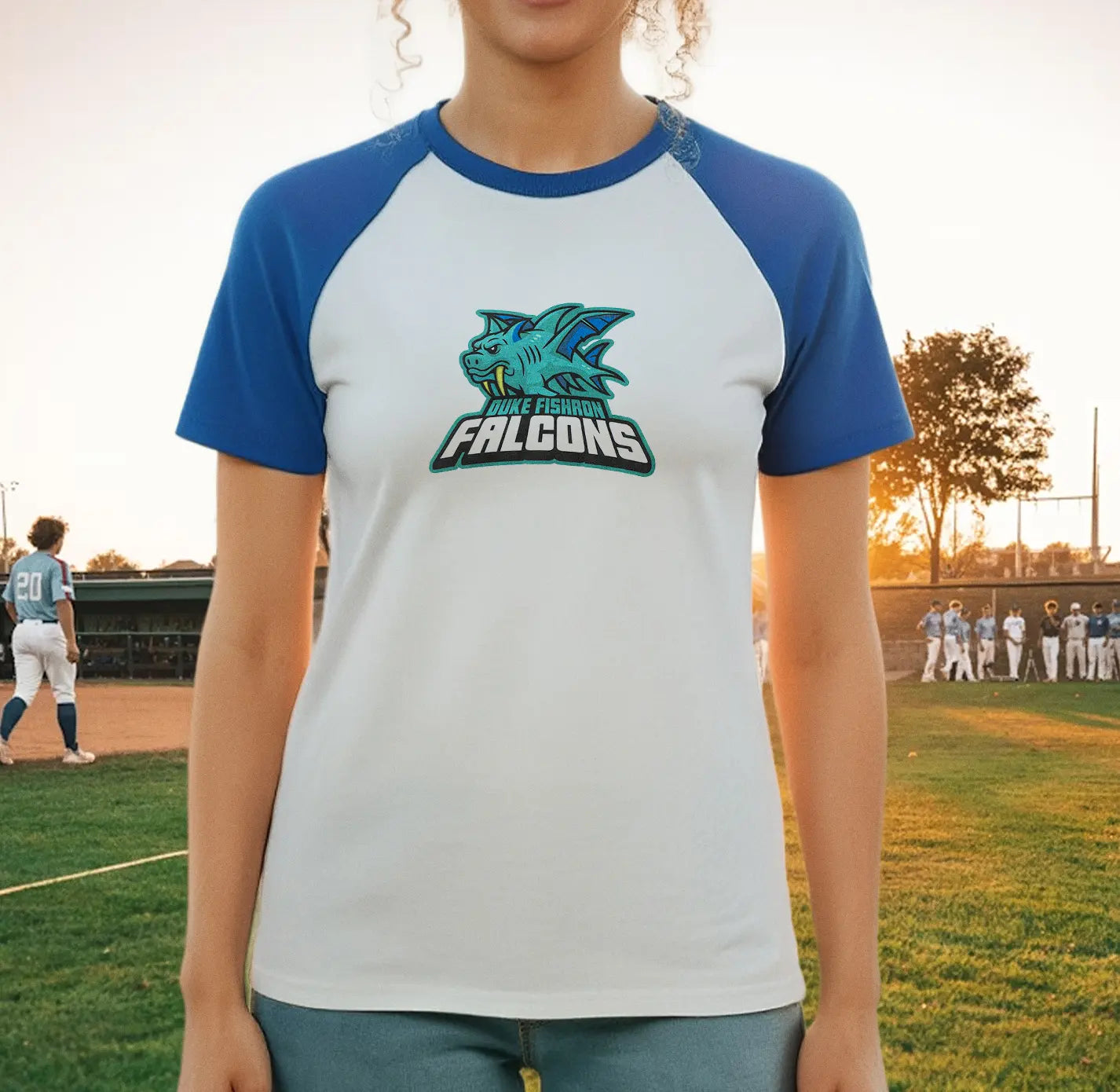 Person wearing a blue and white t-shirt with a Duke Fishron logo from Terraria on a baseball field.